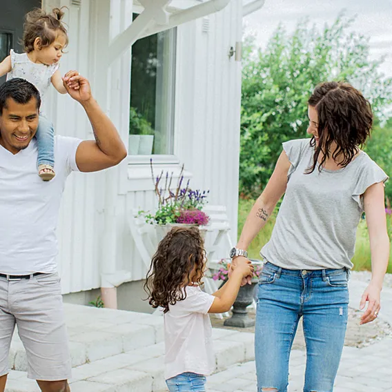 Glad familj utanför hus