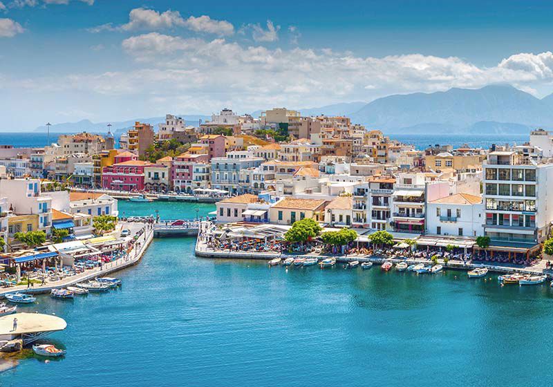 Stad på Kreta direkt vid havet med berg i bakgrunden