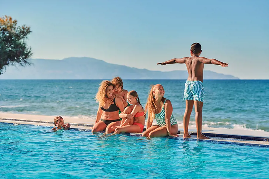 kvinna och barn vid pool på semester