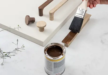 Hand som målar skåpbeslag