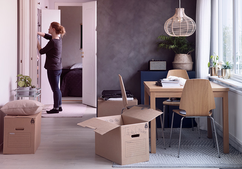 Kvinna som står i ett kök med flyttlådor