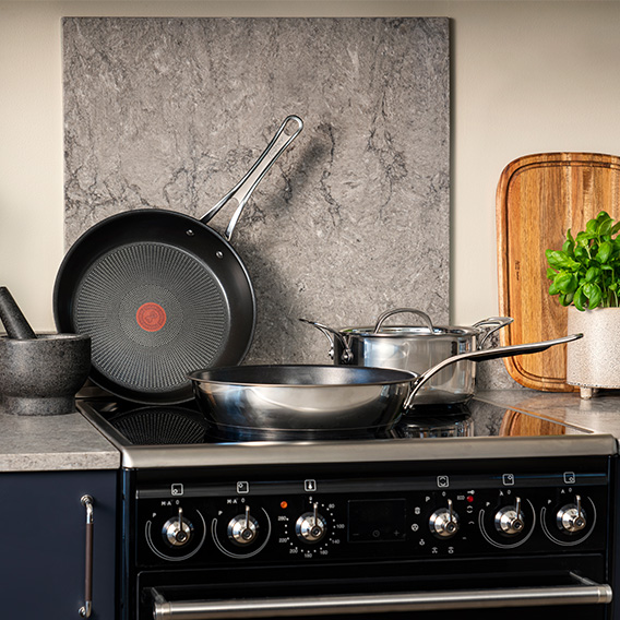 stekpannor och kastrull som står på en spis