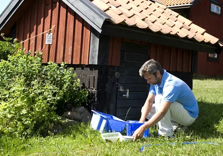 Man diskar i baljor utanför hus